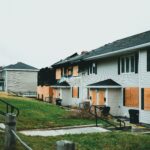 Boarded-up suburban homes with visible fire damage and neglect.